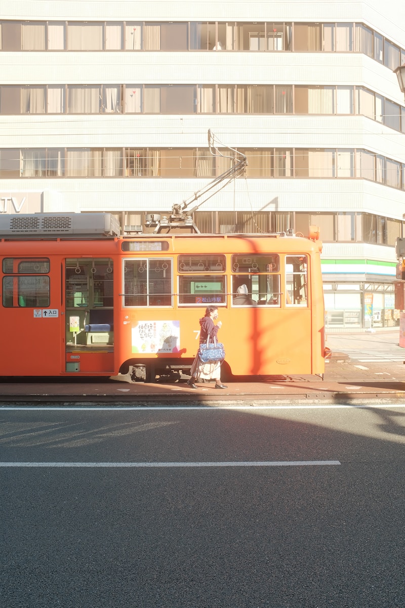 an orange bus is parked on the side of the road